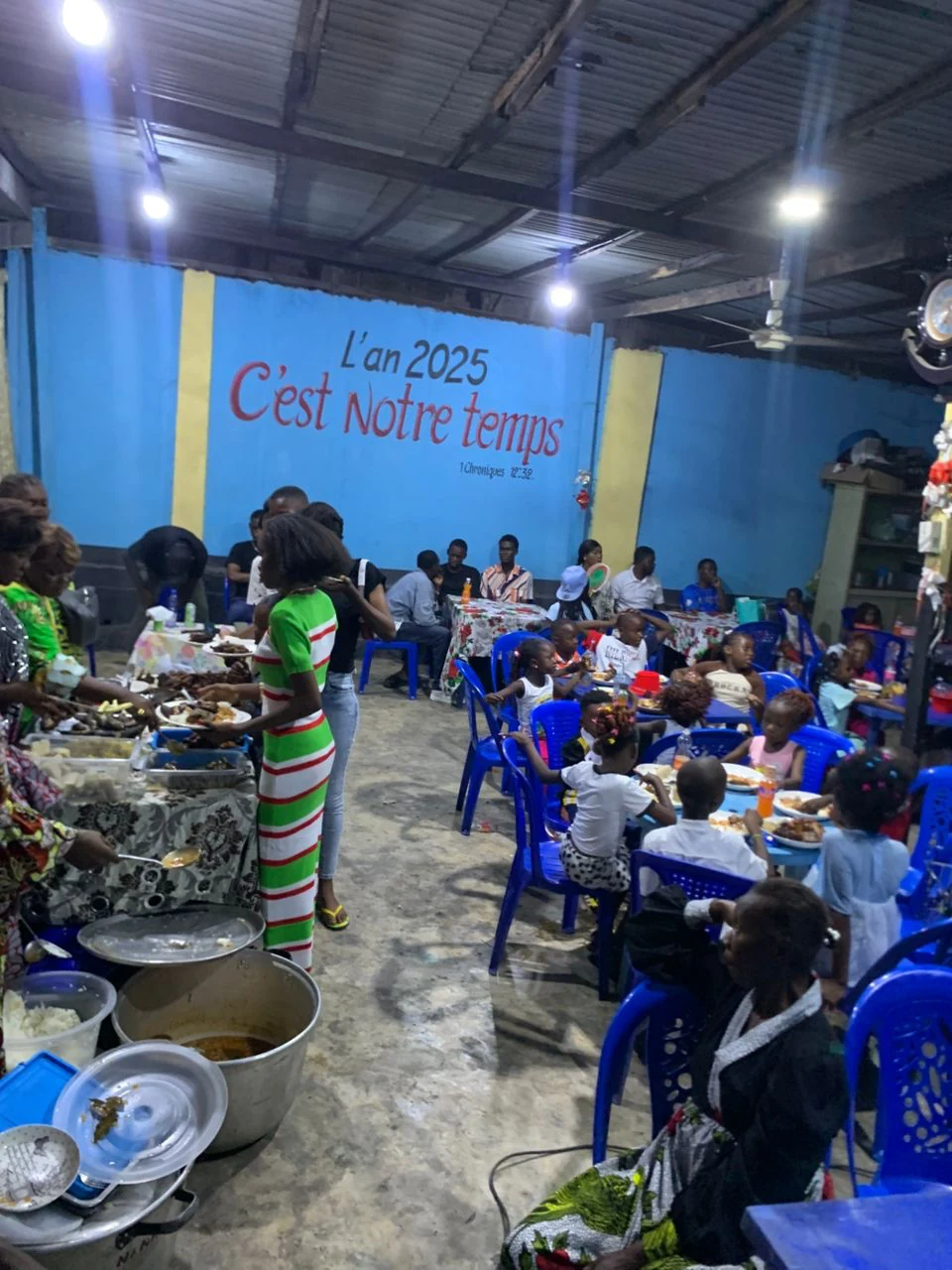 Crianças e famílias reunidas durante a obra número 10 da MBA Maluta Foundation